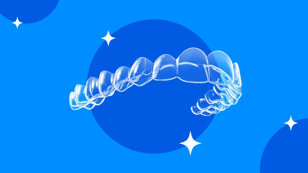 A set of clear aligners against a sparkly blue background